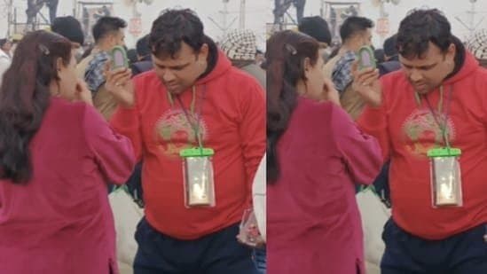 Woman touches up makeup as husband holds mirror for her at Mahakumbh Mela gnr 