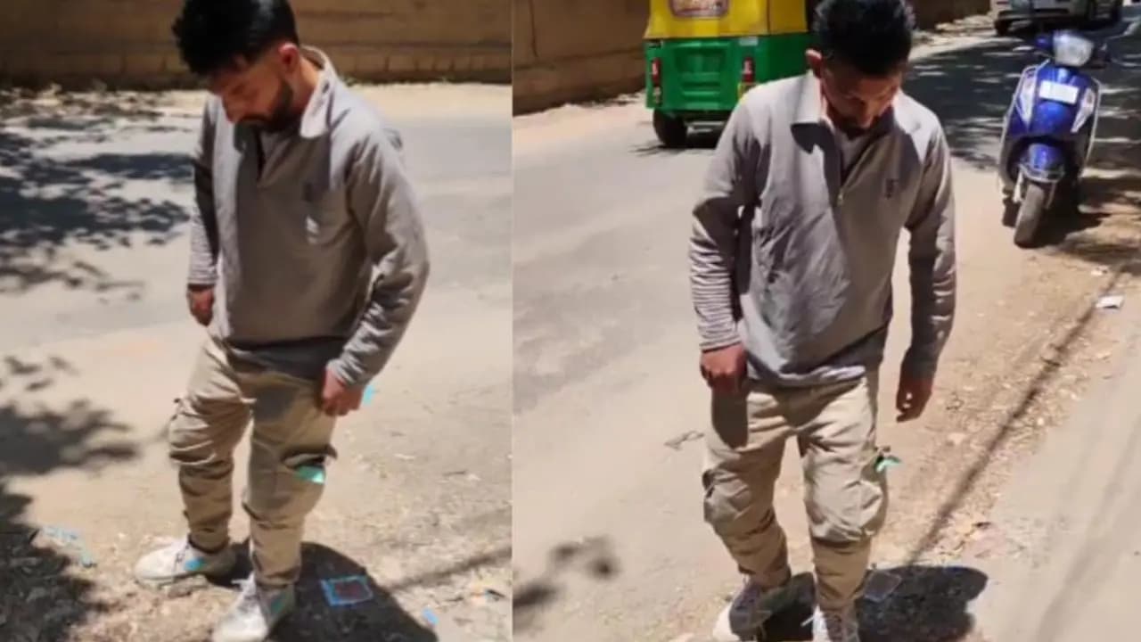A young man standing in the middle of bengaluru road with his eyes closed