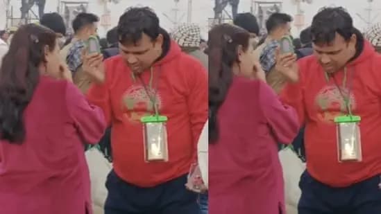 Woman touches up makeup as husband holds mirror for her at Mahakumbh Mela gnr 