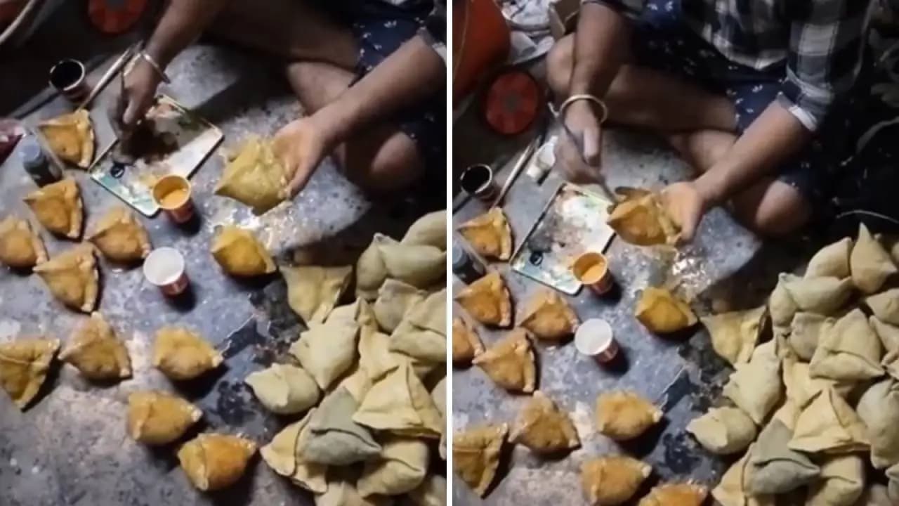 A Man Painting Samosas With A Brush 
